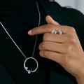 Serti sur Vide pendant in white gold with 2 pear cut diamonds and 1 pear cut emerald